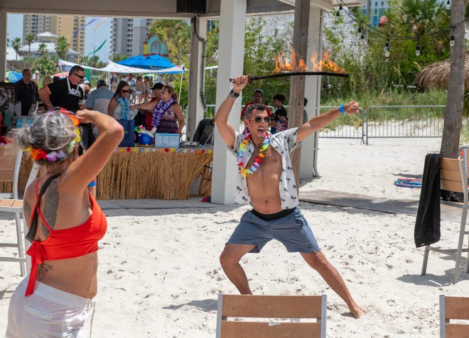 Adam Guarno berpose untuk foto dengan pedang menyala selama Whiskey Joe's dan Defenders of Freedom Veterans Luau di Pantai Pensacola. Luau tersebut menampilkan Babi Panggang dan makanan ringan bertema Pulau oleh Chef Kara Mardell, musik live, penari api, Penari Polinesia, dan lelang rahasia untuk memberi manfaat bagi veteran setempat.